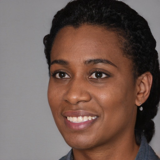 Joyful black young-adult female with short  black hair and brown eyes