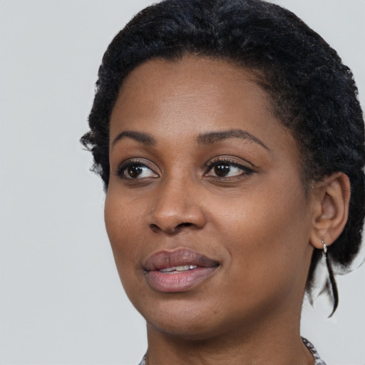 Joyful black young-adult female with short  black hair and brown eyes
