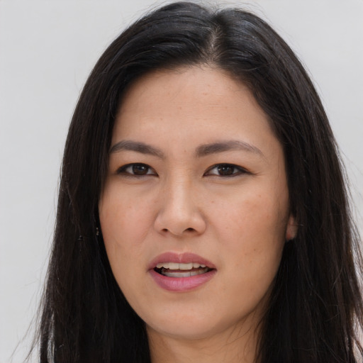 Joyful asian young-adult female with long  brown hair and brown eyes