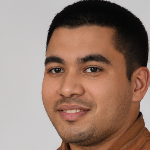 Joyful latino young-adult male with short  black hair and brown eyes