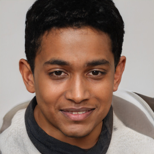 Joyful black young-adult male with short  brown hair and brown eyes