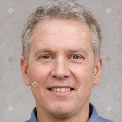 Joyful white middle-aged male with short  brown hair and grey eyes