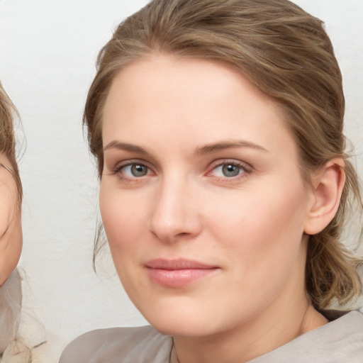 Joyful white young-adult female with medium  brown hair and blue eyes