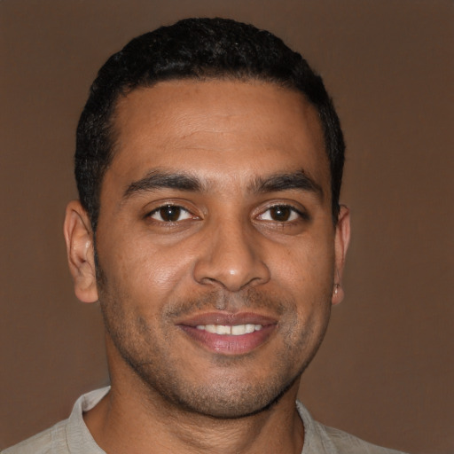 Joyful black young-adult male with short  brown hair and brown eyes