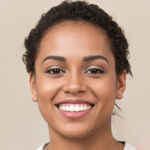 Joyful latino young-adult female with short  brown hair and brown eyes