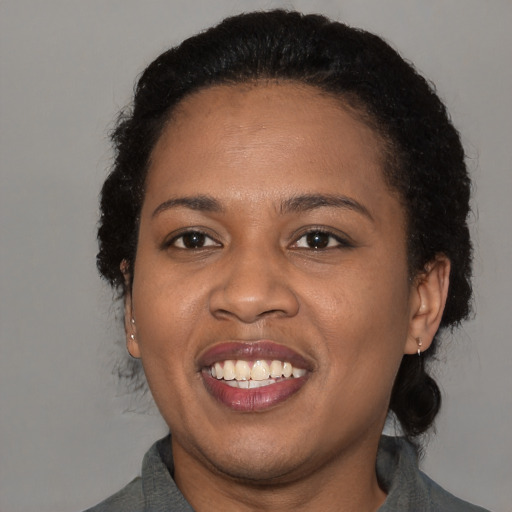 Joyful black adult female with medium  black hair and brown eyes