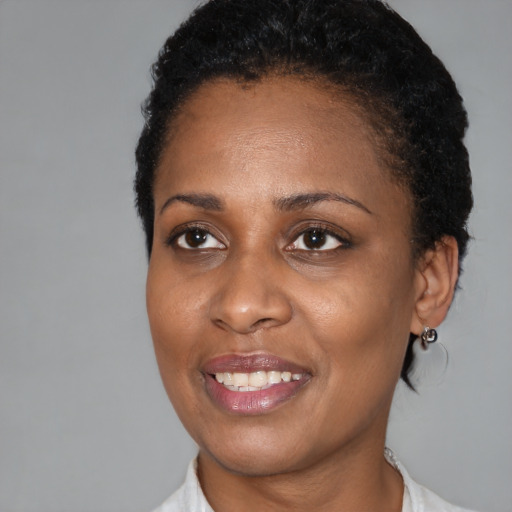 Joyful black young-adult female with short  black hair and brown eyes