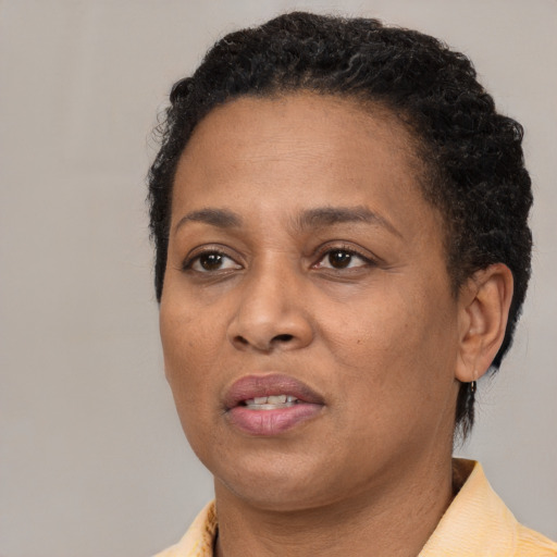 Joyful black adult female with short  brown hair and brown eyes