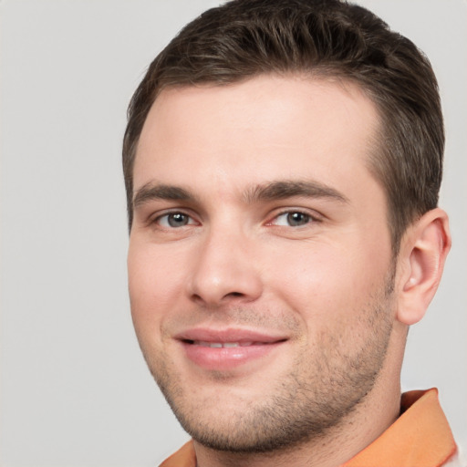 Joyful white young-adult male with short  brown hair and brown eyes