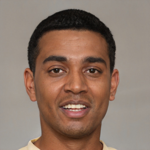 Joyful black young-adult male with short  black hair and brown eyes