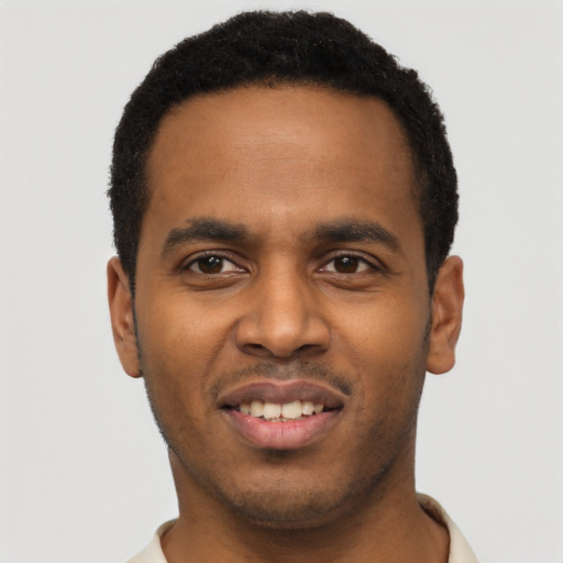Joyful black young-adult male with short  black hair and brown eyes