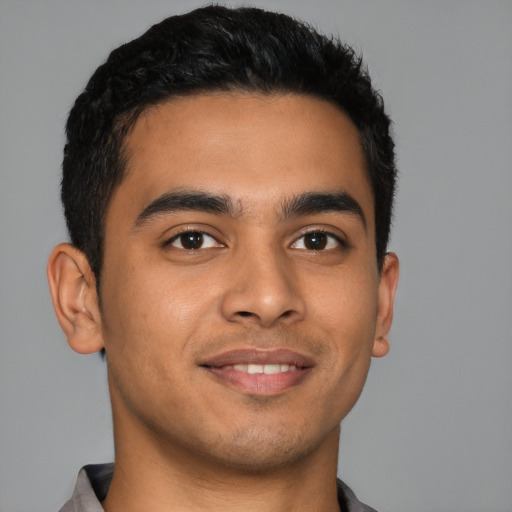 Joyful latino young-adult male with short  brown hair and brown eyes