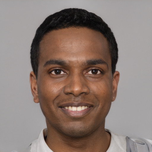 Joyful black young-adult male with short  black hair and brown eyes