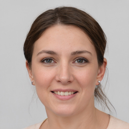 Joyful white young-adult female with medium  brown hair and grey eyes