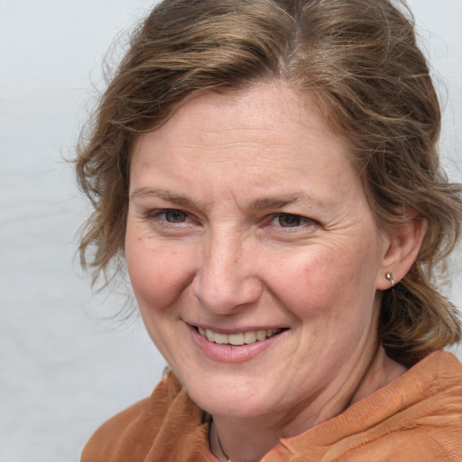 Joyful white adult female with medium  brown hair and brown eyes