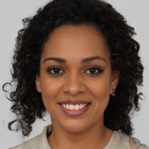 Joyful black young-adult female with medium  brown hair and brown eyes