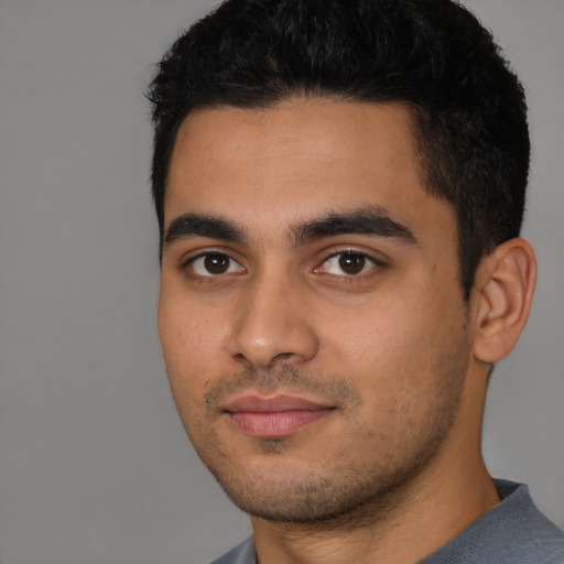 Joyful latino young-adult male with short  black hair and brown eyes