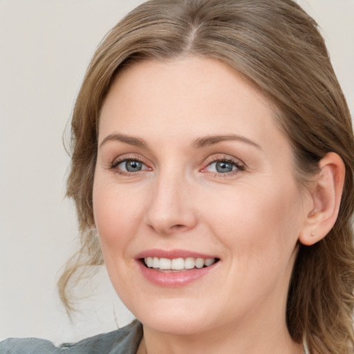 Joyful white young-adult female with medium  brown hair and blue eyes