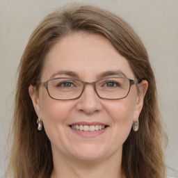 Joyful white adult female with long  brown hair and grey eyes