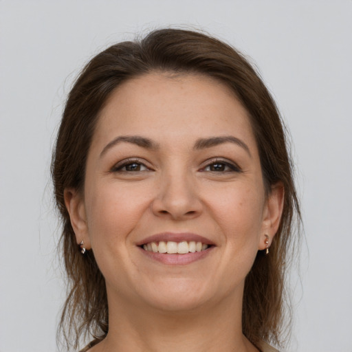 Joyful white young-adult female with medium  brown hair and grey eyes