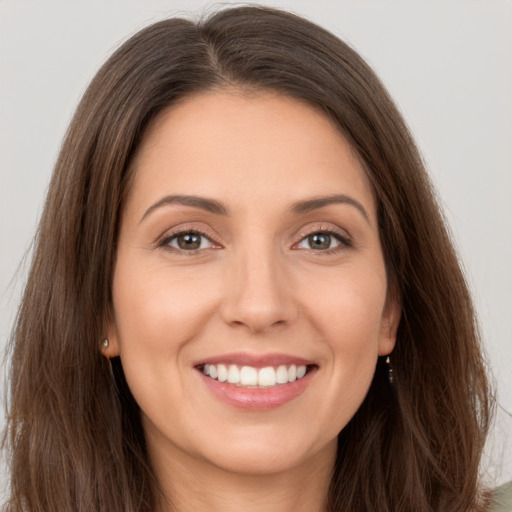 Joyful white young-adult female with long  brown hair and brown eyes