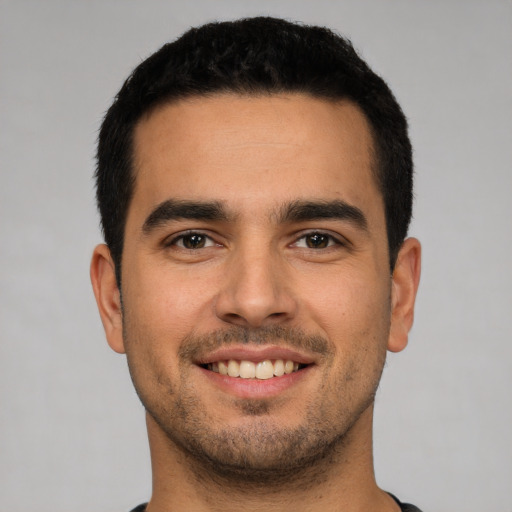 Joyful white young-adult male with short  black hair and brown eyes