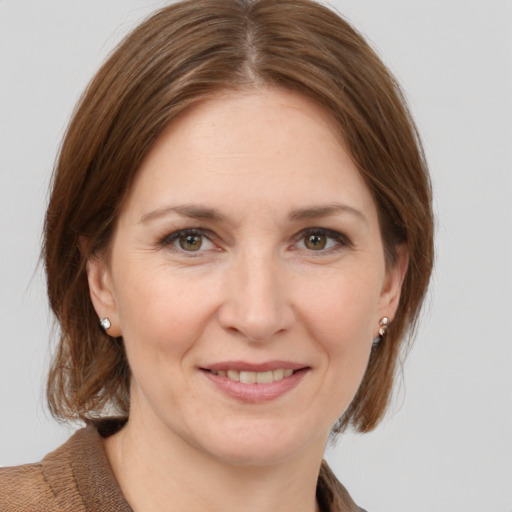 Joyful white adult female with medium  brown hair and grey eyes