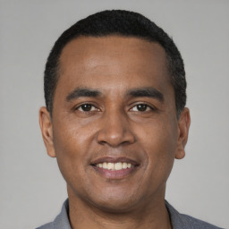 Joyful black young-adult male with short  black hair and brown eyes