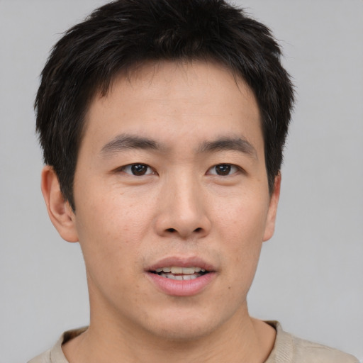 Joyful asian young-adult male with short  brown hair and brown eyes