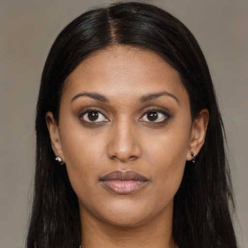 Joyful black young-adult female with long  brown hair and brown eyes
