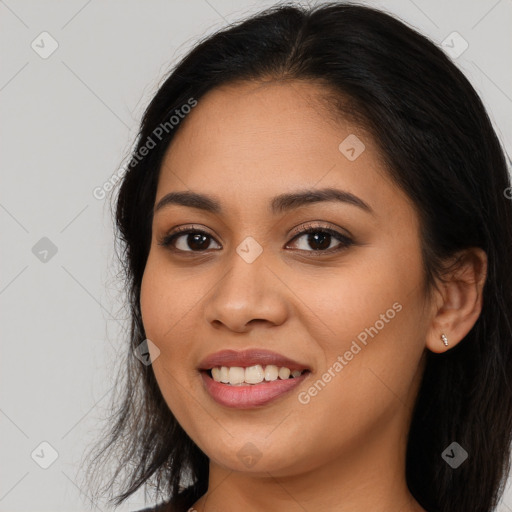 Joyful latino young-adult female with long  brown hair and brown eyes