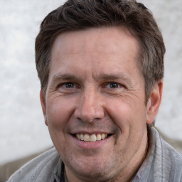 Joyful white adult male with short  brown hair and grey eyes