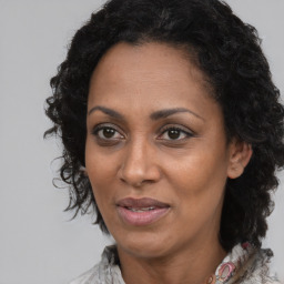 Joyful black adult female with long  brown hair and brown eyes