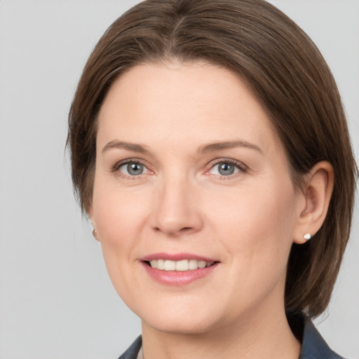 Joyful white adult female with medium  brown hair and grey eyes