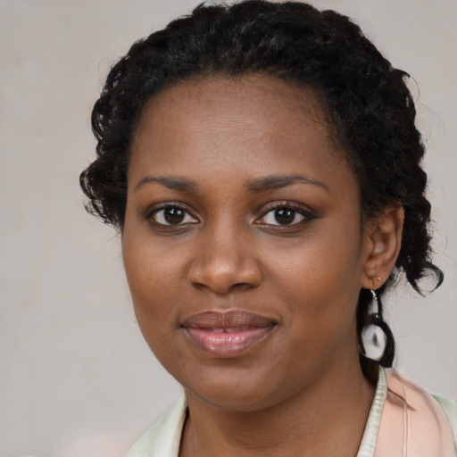 Joyful black young-adult female with long  brown hair and brown eyes