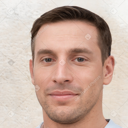 Joyful white young-adult male with short  brown hair and grey eyes