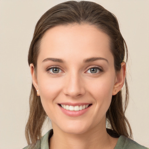 Joyful white young-adult female with long  brown hair and green eyes