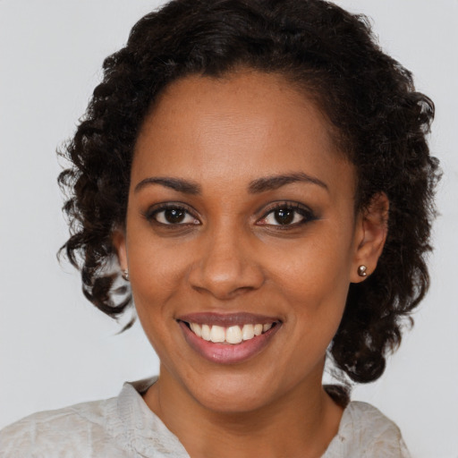 Joyful black young-adult female with medium  brown hair and brown eyes