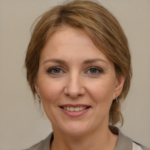 Joyful white adult female with medium  brown hair and grey eyes