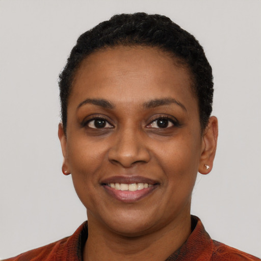 Joyful black young-adult female with short  black hair and brown eyes