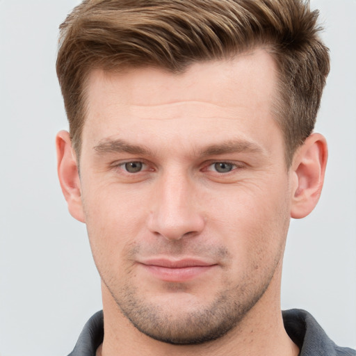 Joyful white young-adult male with short  brown hair and grey eyes