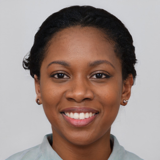 Joyful black young-adult female with short  black hair and brown eyes