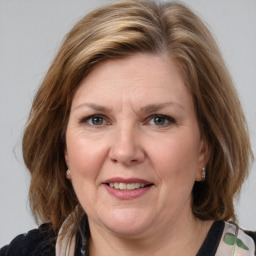 Joyful white adult female with medium  brown hair and blue eyes