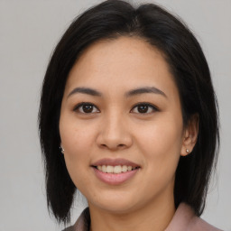 Joyful asian young-adult female with medium  brown hair and brown eyes