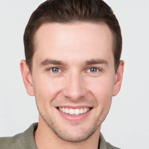 Joyful white young-adult male with short  brown hair and grey eyes