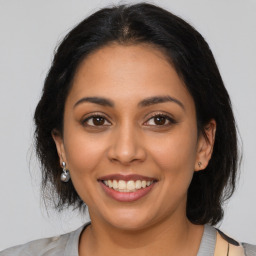 Joyful latino young-adult female with medium  brown hair and brown eyes