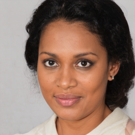 Joyful black adult female with medium  brown hair and brown eyes