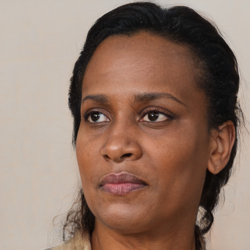 Joyful black adult female with medium  brown hair and brown eyes