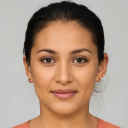 Joyful latino young-adult female with medium  brown hair and brown eyes