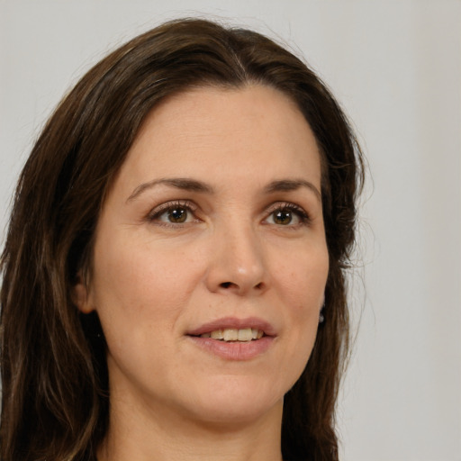 Joyful white adult female with long  brown hair and brown eyes